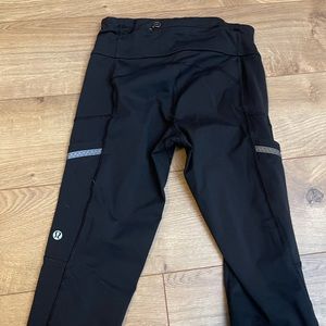 Black lululemon cropped leggings with side pockets and reflective detail